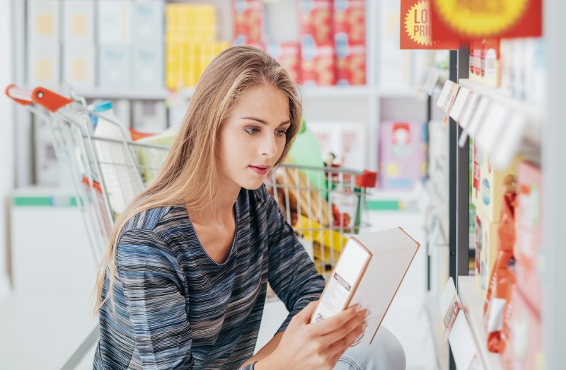 Frau liest Zutatenliste im Supermarkt
